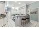 Bright kitchen with white cabinetry, bar seating, and tile floors at 18739 Bascomb Ln, Hudson, FL 34667