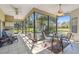 Enclosed lanai with ceiling fans and outdoor furniture, perfect for relaxing and enjoying views of the backyard at 18739 Bascomb Ln, Hudson, FL 34667