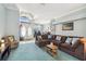 Spacious living room with blue carpet, large sectional sofa, and a view of the front entrance at 18739 Bascomb Ln, Hudson, FL 34667