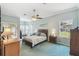 Serene main bedroom with blue carpet, a ceiling fan, and a sliding door to the lanai at 18739 Bascomb Ln, Hudson, FL 34667