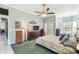 Bright main bedroom featuring blue carpet, a ceiling fan, and sliding door access to the lanai at 18739 Bascomb Ln, Hudson, FL 34667