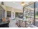 Relaxing screened patio with a table, chairs, ceiling fans, and peaceful views, perfect for outdoor entertaining at 18739 Bascomb Ln, Hudson, FL 34667