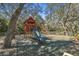 Neighborhood playground with a wooden playset, slide, and swing set, nestled under mature trees at 18739 Bascomb Ln, Hudson, FL 34667