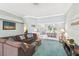 Comfortable sitting room with blue carpet, large sectional sofa, and a sliding door to the lanai at 18739 Bascomb Ln, Hudson, FL 34667