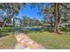 Pathway leading to gated tennis courts in a well-maintained community recreational area at 18739 Bascomb Ln, Hudson, FL 34667