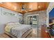 Comfortable bedroom featuring a wood plank ceiling, stone accent wall, and sliding glass doors to the backyard at 2227 29Th S St, St Petersburg, FL 33712