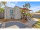 Charming stucco home featuring a unique covered porch with a thatched roof and tropical landscaping at 2227 29Th S St, St Petersburg, FL 33712