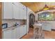 Bright kitchen features white cabinets, terracotta tile floors, and an archway to another room at 2227 29Th S St, St Petersburg, FL 33712