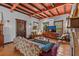 Comfortable living room featuring an exposed beam ceiling, tile flooring, and a vintage-style sofa at 2227 29Th S St, St Petersburg, FL 33712