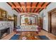 Inviting living room with terracotta floors, exposed ceiling beams, and a fireplace with a brick hearth at 2227 29Th S St, St Petersburg, FL 33712