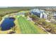 Aerial view of community condos overlooking a well-manicured golf course and pond at 2333 Feather Sound Dr # A308, Clearwater, FL 33762