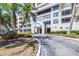 Condo entrance with lush greenery, mature palms, and a well-maintained driveway at 2333 Feather Sound Dr # A308, Clearwater, FL 33762