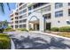 Exterior view of the building entrance with a covered drop-off area and lush landscaping at 2333 Feather Sound Dr # A308, Clearwater, FL 33762