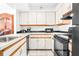 Efficient kitchen with white cabinetry, modern appliances, and sleek countertops at 2333 Feather Sound Dr # A308, Clearwater, FL 33762