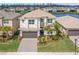 Aerial view of a two-story home with manicured lawn, landscaping, and lake view at 3107 Mountain Spruce Ter, Wesley Chapel, FL 33543