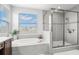 Beautiful bathroom featuring a glass-enclosed shower and a large tub under a window at 3107 Mountain Spruce Ter, Wesley Chapel, FL 33543