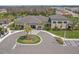Exterior shot of the clubhouse with a circular driveway, lush landscaping, and ample parking at 3107 Mountain Spruce Ter, Wesley Chapel, FL 33543