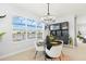Modern dining room with waterfront views, a stylish chandelier, and a chic black display cabinet at 3107 Mountain Spruce Ter, Wesley Chapel, FL 33543