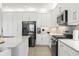 Contemporary kitchen featuring stainless steel appliances, white cabinetry, and an island with countertop seating at 3107 Mountain Spruce Ter, Wesley Chapel, FL 33543