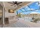 Entertain on your patio with a ceiling fan, TV, outdoor bar, and a view of the pool and the lake at 3107 Mountain Spruce Ter, Wesley Chapel, FL 33543