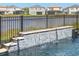 Close-up of a serene waterfall feature flowing into the clear, blue pool at 3107 Mountain Spruce Ter, Wesley Chapel, FL 33543