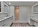 Bright bathroom featuring dual sinks, quartz counters, wood floors, and a toilet room at 313 Martha Ln # 4, Oldsmar, FL 34677