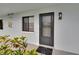 View of the entrance of unit 313 with plants in foreground and black framed windows at 313 Martha Ln # 4, Oldsmar, FL 34677
