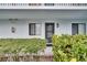 Close-up of unit entrance with well-manicured shrubs and black framed windows at 313 Martha Ln # 4, Oldsmar, FL 34677