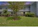 Low angle view of condo building with manicured lawn, and lush landscaping at 313 Martha Ln # 4, Oldsmar, FL 34677
