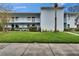 Two-story condo building with well-maintained lawn and a palm tree in a tropical setting at 313 Martha Ln # 4, Oldsmar, FL 34677
