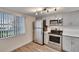 Bright kitchen featuring stainless appliances, light grey cabinets, and view of a window at 313 Martha Ln # 4, Oldsmar, FL 34677