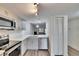 Modern kitchen featuring stainless steel appliances, light grey cabinets, and view of living room at 313 Martha Ln # 4, Oldsmar, FL 34677