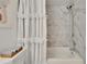 A shower showcases the decorative shower curtain and marble-look shower surround at 313 Martha Ln # 4, Oldsmar, FL 34677