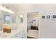 Bright bathroom with double vanity, a well-lit mirror, and views into an adjacent bedroom and play area at 3598 10Th Ne St, St Petersburg, FL 33704