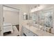 Well-lit bathroom features a double vanity, modern lighting, and views into an adjacent bedroom with nautical theme at 3598 10Th Ne St, St Petersburg, FL 33704
