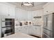 Bright kitchen featuring modern stainless steel appliances, white cabinets, and white tile backsplash at 3598 10Th Ne St, St Petersburg, FL 33704