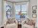 Cozy sitting area with two chairs overlooking a waterfront view through window with palm trees at 3598 10Th Ne St, St Petersburg, FL 33704