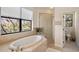 Bright main bathroom features a large soaking tub with tile surround, glass shower, and waterfront views at 3598 10Th Ne St, St Petersburg, FL 33704