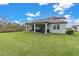 Expansive green backyard featuring a covered patio with outdoor seating, perfect for relaxation and entertainment at 3610 Aberdeen Gait Ct, Odessa, FL 33556