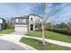 Charming two-story home with a stone facade, a well-manicured lawn, and a view of a nearby lake at 3610 Aberdeen Gait Ct, Odessa, FL 33556