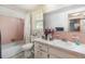 Bathroom with pink tile, classic fixtures, and natural light at 375 Magnolia Rd, Venice, FL 34293