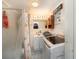 This functional bathroom combines laundry facilities with a shower, streamlining household tasks at 375 Magnolia Rd, Venice, FL 34293