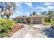 Cozy home showcasing a sunny front facade and mature tropical landscaping at 375 Magnolia Rd, Venice, FL 34293
