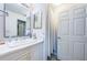 This bathroom features a vanity with marble countertops, patterned tile floors, and a white shower curtain at 3850 6Th N Ave, St Petersburg, FL 33713