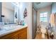 The bathroom features a single sink with a wood cabinet, a shower with curtain, and a large mirror at 3850 6Th N Ave, St Petersburg, FL 33713