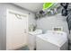 This bright laundry room has white washer and dryer units with shelving for organized storage at 3850 6Th N Ave, St Petersburg, FL 33713
