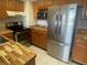 Modern kitchen featuring stainless steel appliances, tile flooring, and wooden countertop at 400 Island Way # 908, Clearwater Beach, FL 33767
