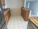Efficient kitchen layout with tile flooring, wood cabinets, and a breakfast bar at 400 Island Way # 908, Clearwater Beach, FL 33767