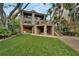 Home's backyard featuring a multi-level deck, stone patio, and manicured landscaping at 4035 N River View Ave, Tampa, FL 33607