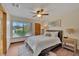 Bright bedroom featuring a ceiling fan, large window, and hardwood floors at 4035 N River View Ave, Tampa, FL 33607